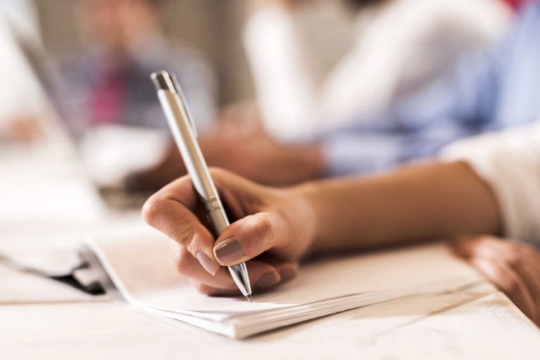 Unrecognizable person writing on a piece of paper